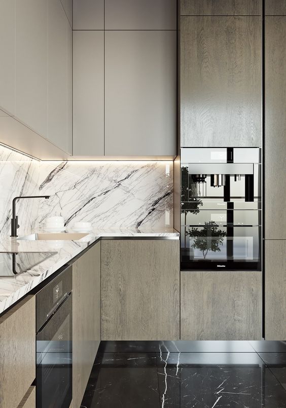 a light-colored wooden kitchen with a chic marble backsplash and countertops for a bold touch