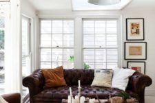 11 a creamy sunroom with dark leather furniture and a vintage chest for storage