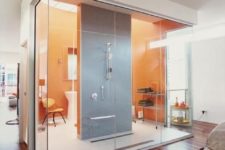 11 a modern glass-enclosed bathroom with orange and grey tiles right in the interior