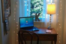 11 a tiny workspace by the window with string lights to enlighten it better
