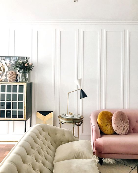 molding on the walls adds instant chic to the living room and some pastel touches make it look softer