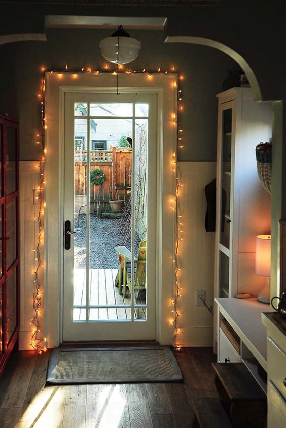 the entry door covered with string lights to add light to the space and highlight the door