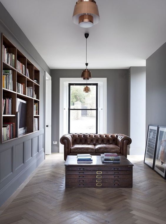 a laconic home library with a unique coffee table and a brown leather sofa