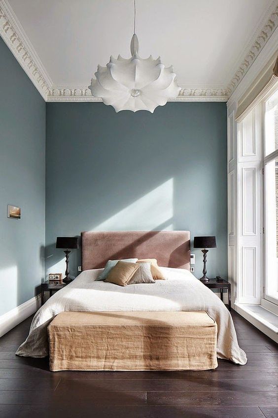 a quirky and whimsy bedroom with interesting furniture, molding and lamps balanced with negative space