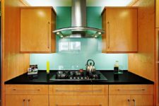 12 oversized turquoise tiles on the backsplash stand out in a warm-colored kitchen