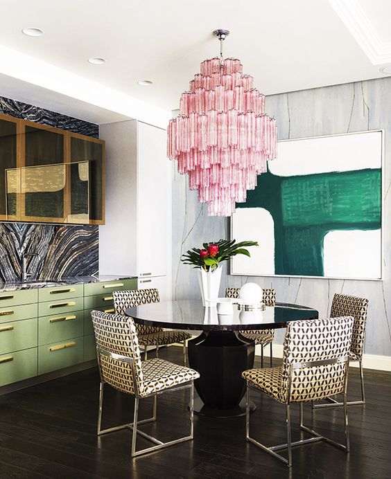 the dining space is highlighted with an oversized pink chandelier that contrasts the space