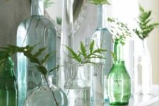 13 sheer vases and bottles in green shades with leaves in them for a fresh feeling