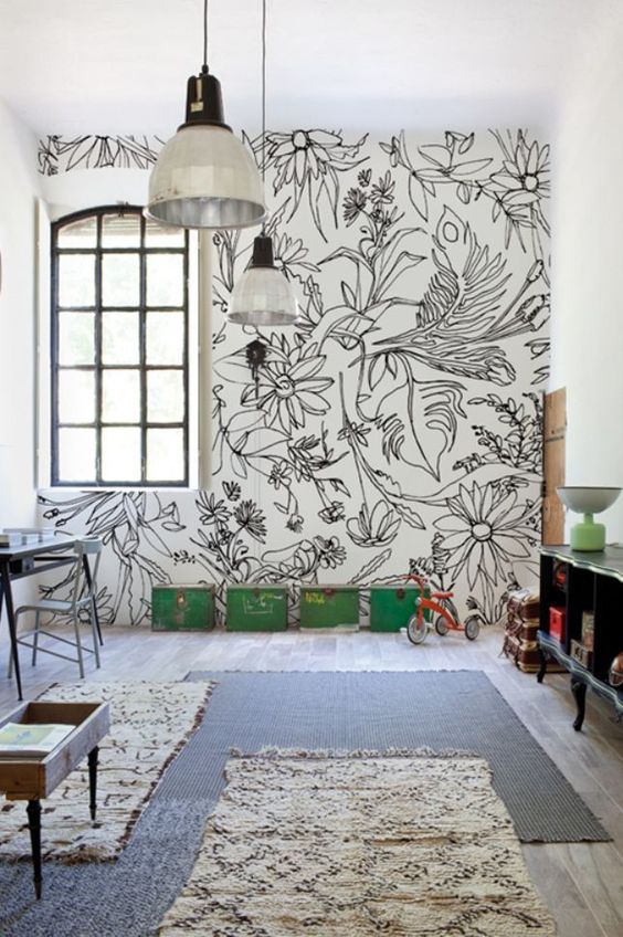 a kid's playroom is accented with a graphic floral wall and matching rugs