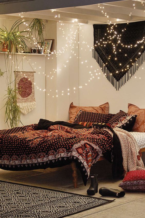 lots of string lights over the bedadd a magical feel to this boho bedroom