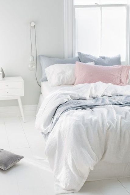 some powder blue and blush pillows will turn a white bed into a springy