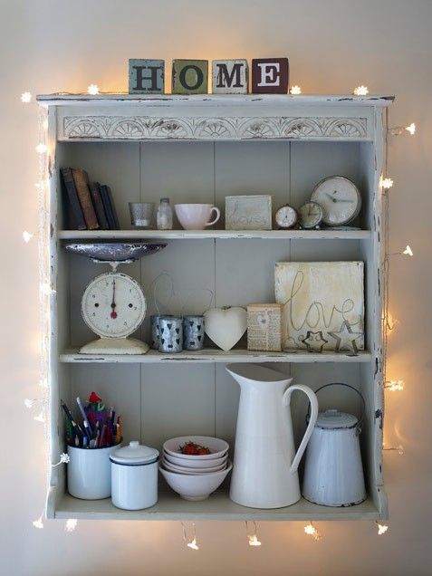 attach some string lights to a usual open cabinet in your kitchen to turn it into a chic display