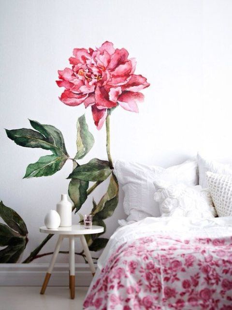 a bold pink bloom painted on the wall next to the bed for a girlish space