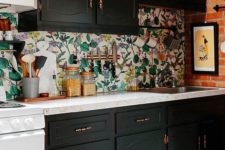 17 a kitchen backsplash done with floral wallpaper to stand out in a black kitchen