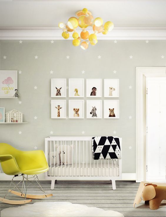 a cheerful dove grey and yellow nursery with animal pics, a polka dot wall and a fun chandelier