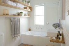 18 light-colored wooden box and open shelving add a warm touch to the bathroom