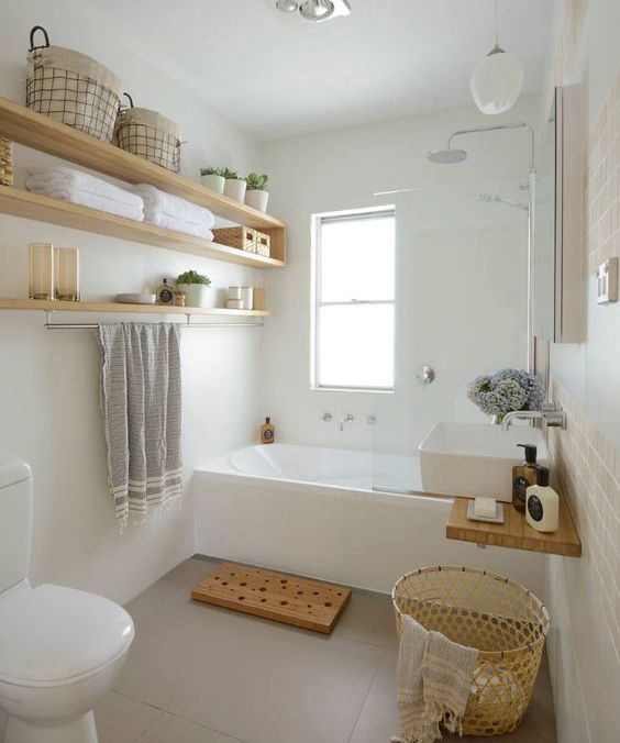 Light colored wooden box and open shelving add a warm touch to the bathroom