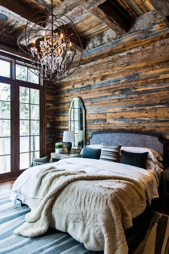 a rustic chalet bedroom done with an industrial chandelier with crystals that makes the space cooler