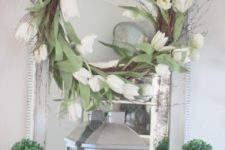 19 a wreath with white tulips, potted boxwood and a lantern with eggs in a nest
