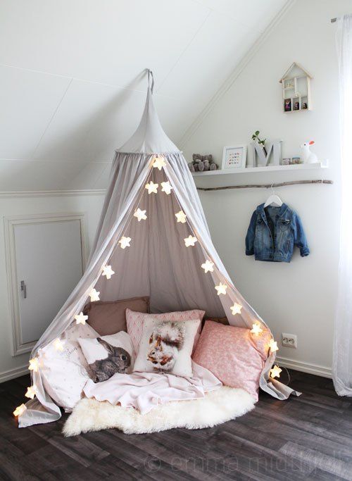 a cute tent for reading and playing with star-shaped string lights to add more light to the corner