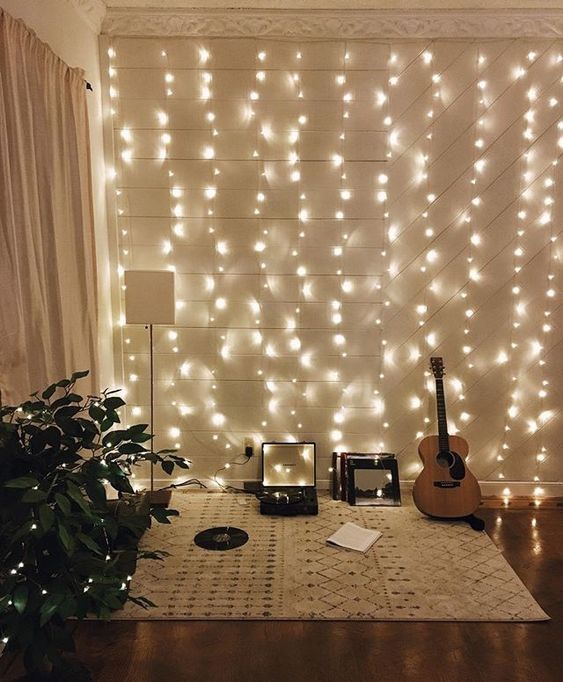 a hobby nook in the living room is accented with a whole string lights wall