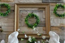 20 little boxwood wreaths, potted greenery, faux eggs and porcelain bunnies for a traditional mantel