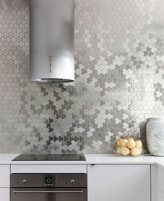neutral kitchen with stainless steel appliances and silver geometric tiles