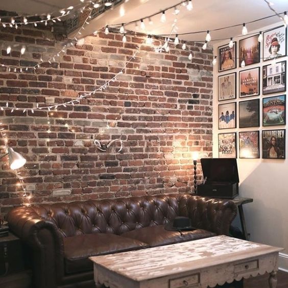 an industrial living room with lots of string lights all over the room