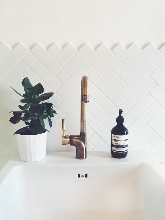 clad a bathroom backsplash with long and narrow tiles in a chevron pattern