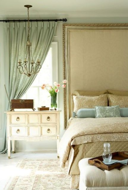 the neutral bedroom is spruced up with a mint-colored curtain and matching pillows
