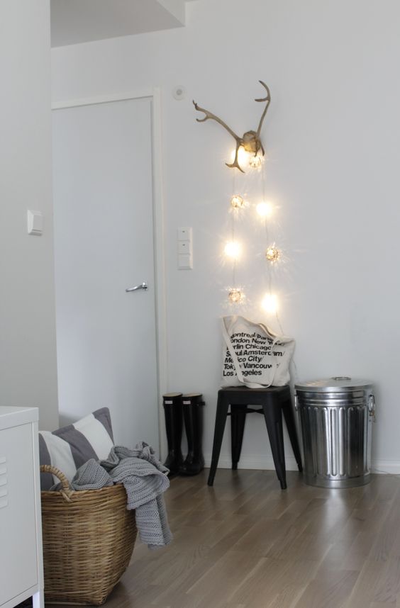 hang some creative lights on the antlers that you use as a coat and scarf hanger