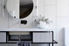 26 oversized white tiles create a wow effect in this bathroom and black grout helps to accent them