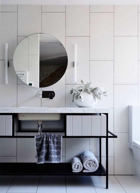 oversized white tiles create a wow effect in this bathroom and black grout helps to accent them