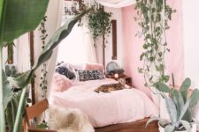 26 potted plants and cascading greenery hanging on the bed frame to feel outside