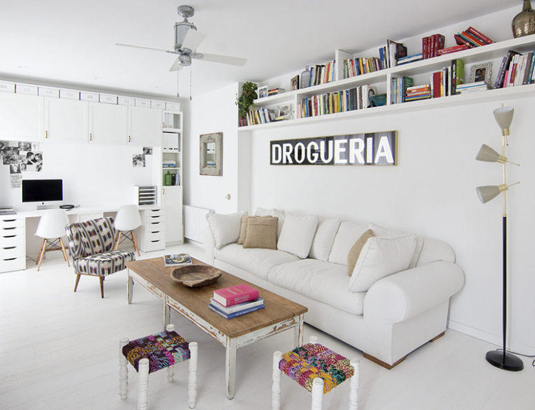 The living room with a home office nook is done with colorful and eclectic furniture