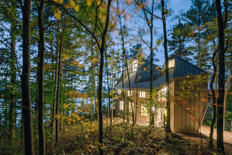 This lakeside house with creative architecture is situated inside a forest on a lake shore