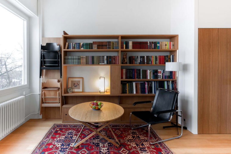 This is a small living reading nook with a large bookshelf and a sitting space plus a view