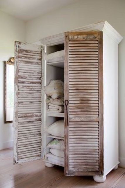 a gorgeous wardrobe with doors changed for old shutters adds texture and sophistication to the space
