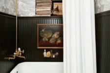 03 a vintage bathroom with a free-standing bathtub and black wainscoting that saves the walls form water