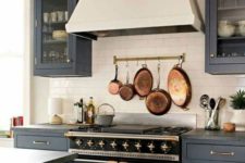 03 make a neutral backsplash more eye-catchy with a rail and vintage pots and frying pans