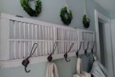 04 a coat rack made from an old shutter and greenery wreaths over it for a cute farmhouse feel