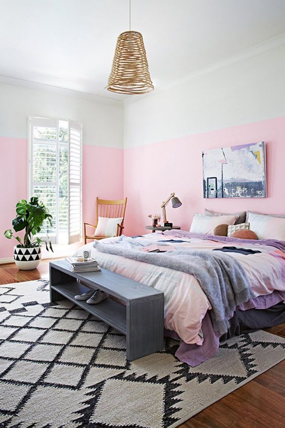 a colorful bedroom with watercolor bedding, a wicker pendant lamp and a vintage storage bench
