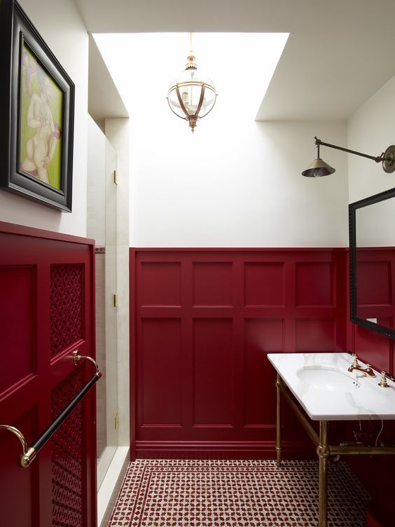 an art deco bathroom with burgundy wainscoting that makes a cool bold statement
