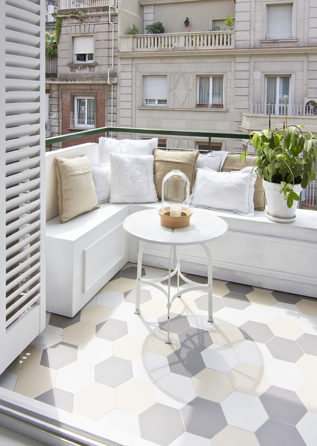 There's a nice and comfy terrace with a geometric tile floor and a comfy nook for breakfast