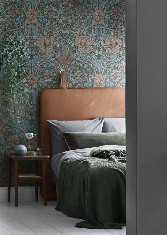 Vintage inspired floral print wallpaper and a leather headboard are an ideal combo for a moody space