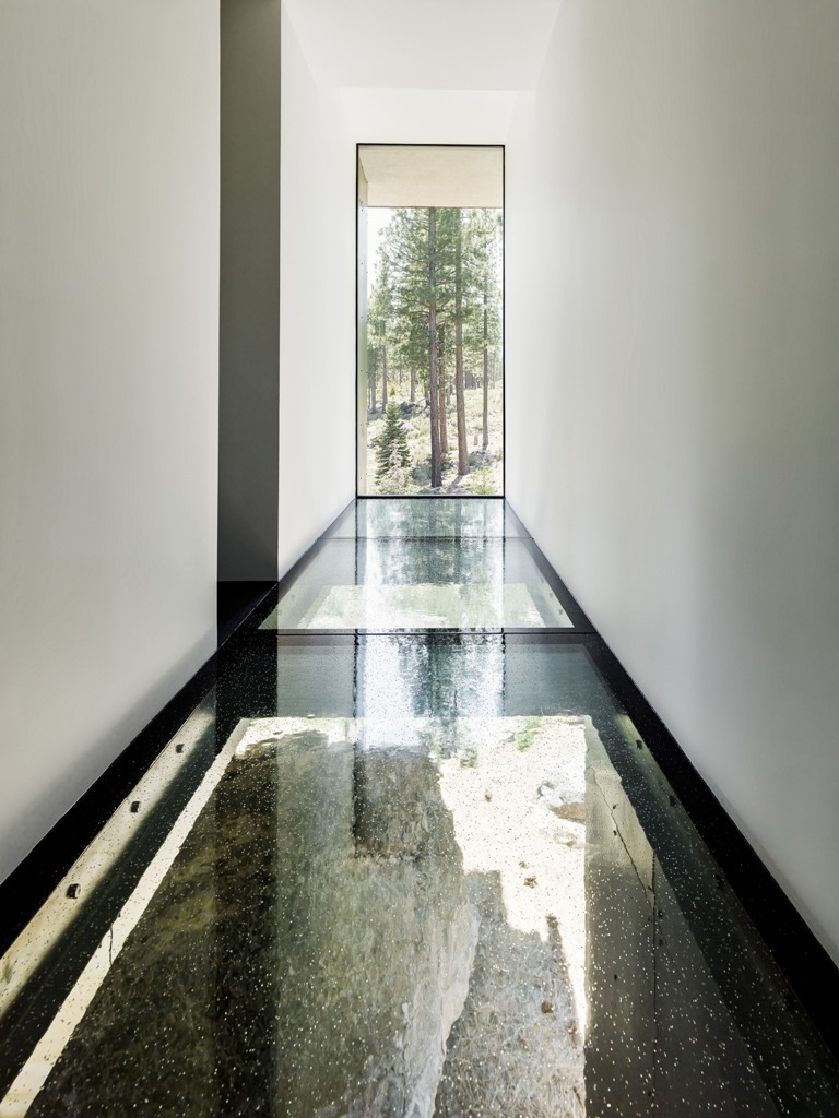 Glass floors here visually remove the boundaries and make the house more light-filled, there's a large double height window