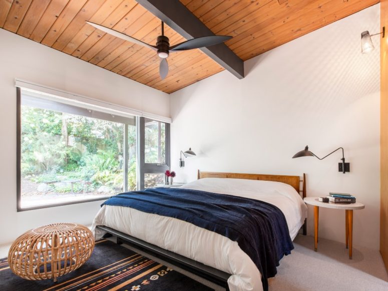 The bedroom features a large window for views and light, and mid-century modern furniture to finish off the look