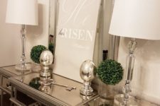 06 an elegant console table with mercury glass eggs and boxwood balls plus a poster
