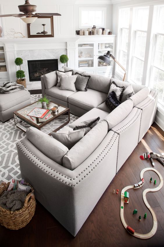 a stylish dove grey L-shaped sectional sofa with a matching ottoman as a basic piece for a living room