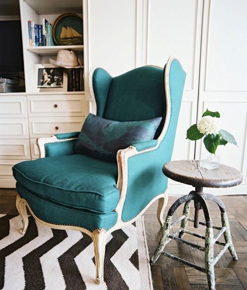 A vintage dark green wingback with light colored wooden framing is a gorgeous statement piece
