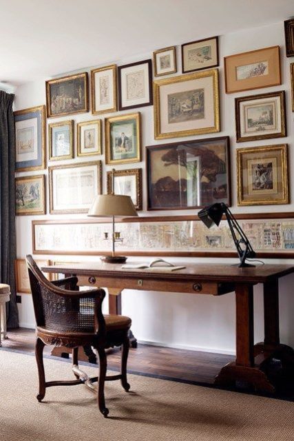 A vintage home office with a gallery wall that takes the whole wall, mismatched frames create a catchy look